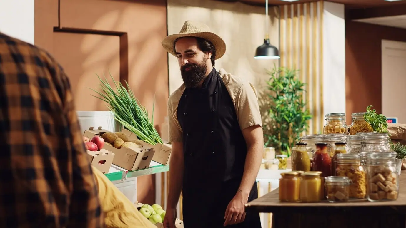 Verkäufer begrüßt die ersten Kunden im neuen Geschäft.