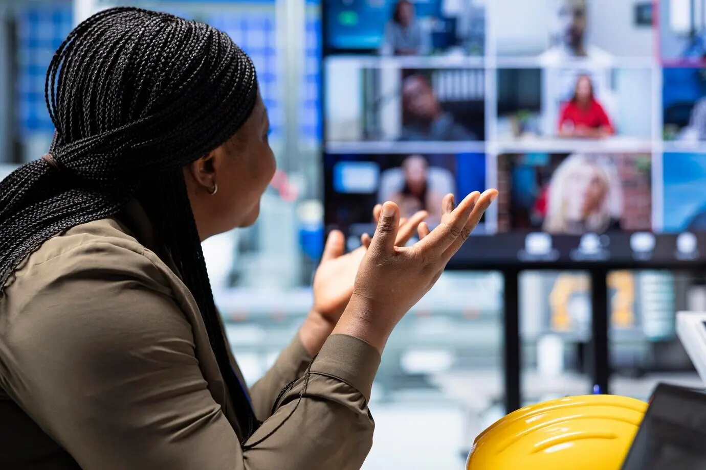 An einer Fabrik interessierte Investoren analysieren während eines Videoanrufs die Erlösströme.